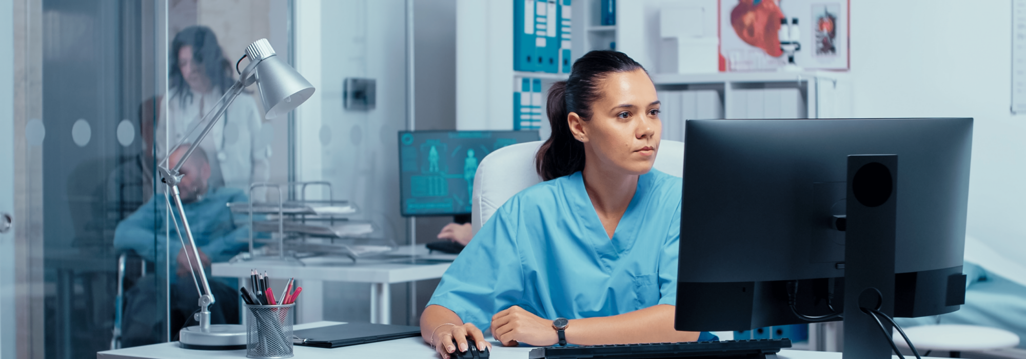 An NHS clinician uses a computer in a hospital office