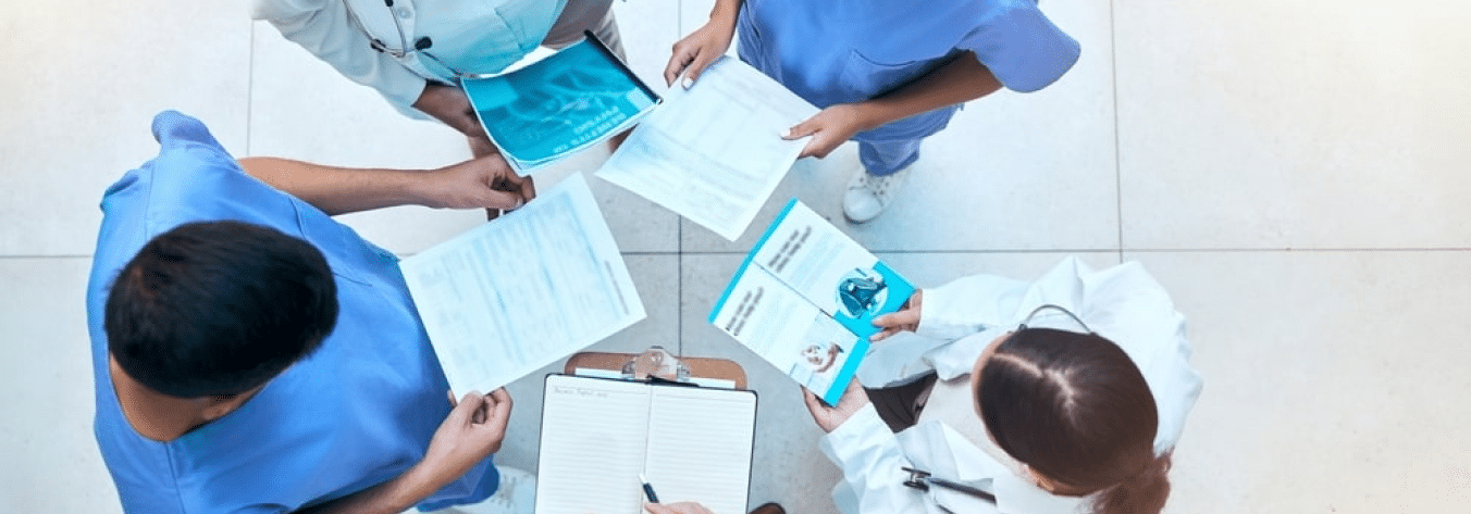 NHS staff standing in a circle working together, shot from above.